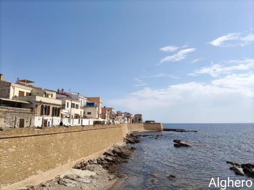 a row of houses on the shore of the ocean at Alabe Hotel Marina di Tresnuraghes in Tresnuraghes