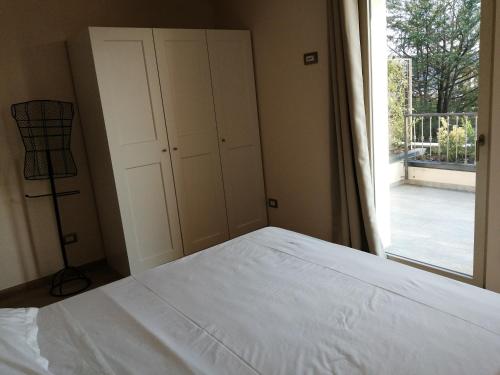 sypialnia z białym łóżkiem i oknem w obiekcie Lattementa w mieście Verbania