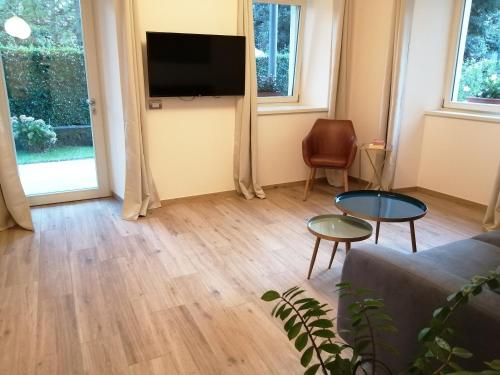 salon z kanapą i telewizorem na ścianie w obiekcie Lattementa w mieście Verbania