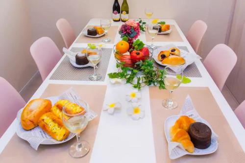 a long table with plates of food and glasses of wine at Condominium Luana 築浅2LDK 宮城海岸徒歩2分 American Village 車で10分 in Chatan
