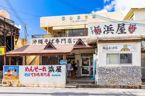 a building with asian writing on the side of it at Condominium Luana 築浅2LDK 宮城海岸徒歩2分 American Village 車で10分 in Chatan