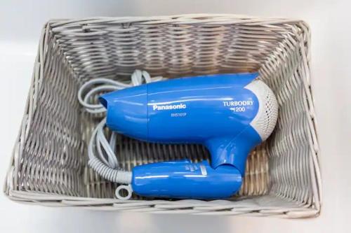 a blue hair dryer in a wire basket at Condominium Luana 築浅2LDK 宮城海岸徒歩2分 American Village 車で10分 in Chatan
