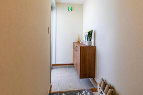 a hallway with a small cabinet in a room at Condominium Luana 築浅2LDK 宮城海岸徒歩2分 American Village 車で10分 in Chatan