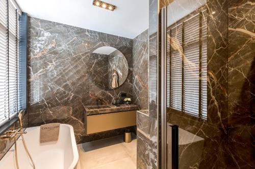 
a bathroom with a bath tub, toilet and sink at Cavallaro Hotel in Haarlem
