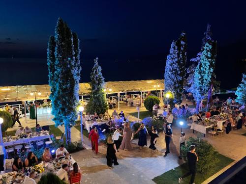 a group of people standing in a courtyard at night at Hotel Millennium in Pogradec
