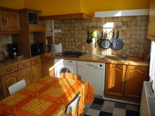 une cuisine avec un évier et une machine à laver dans l'établissement Les Vergnes Mancelles, au Mans