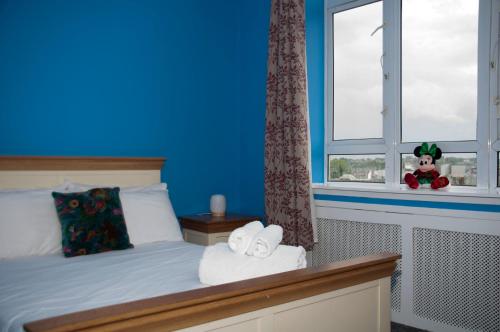 a bedroom with blue walls and a bed with two towels at Home from Home - IONA - Private Members Club in Edinburgh
