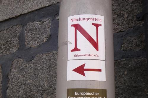 Un poste blanco con una señal. en Gaestehaeuser Am Nibelungensteig, en Lautertal