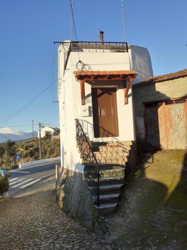 a building with a staircase next to a street at Casa da fonte in Lavacolhos