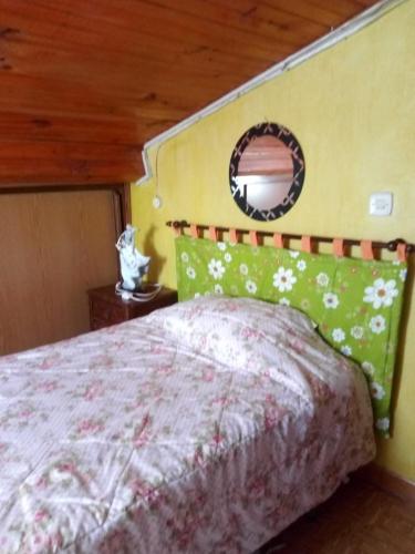 Schlafzimmer mit einem Bett und einem Wandspiegel in der Unterkunft Casa da fonte in Lavacolhos