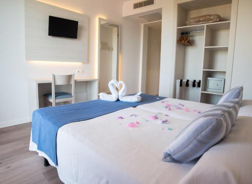 a bedroom with a large bed with flowers on it at Seramar Hotel Luna Park Adults Only in El Arenal
