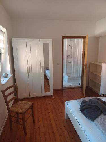 a bedroom with a bed and a chair and a mirror at FeWo s Runde Wiese RW in Greifswald