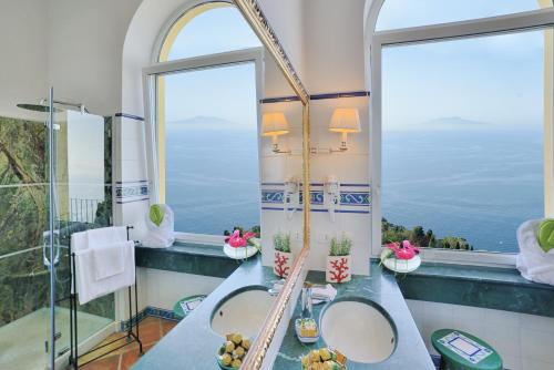 a bathroom with two sinks and a large window at Hotel Caesar Augustus in Anacapri