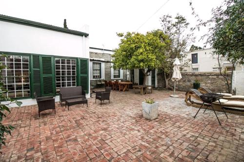 a brick patio with chairs and a table at Garden House in Graaff-Reinet