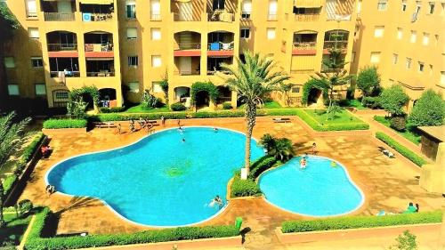 an overhead view of a swimming pool in front of a building at Un Havre de paix a Ricoflores in Mohammedia