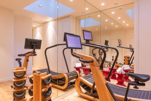 a gym with several exercise bikes in a room at Hotel Yllen Eiffel in Paris