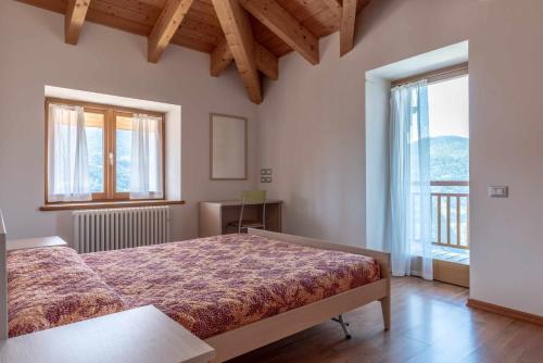 a bedroom with a bed and a large window at Appartamento alla Brisa Grauno Ospitar in Grauno