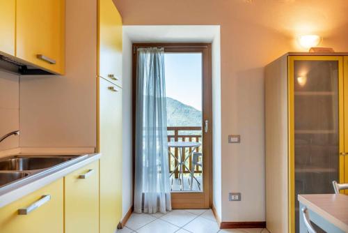 una cucina con porta che conduce a un balcone di Appartamento al Sol Grauno Ospitar a Grauno