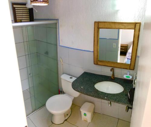 a bathroom with a toilet and a sink and a mirror at Condomínio Porto dos Lençóis - AP02 in Barreirinhas