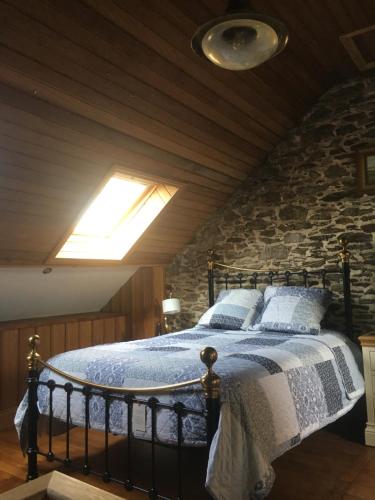 um quarto com uma cama com uma parede de tijolos em Rose by the sea - Beach front sea views em Hirel