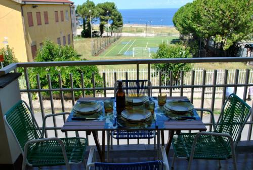 a table and chairs on a balcony with a tennis court at Casa a Cocca in Briatico