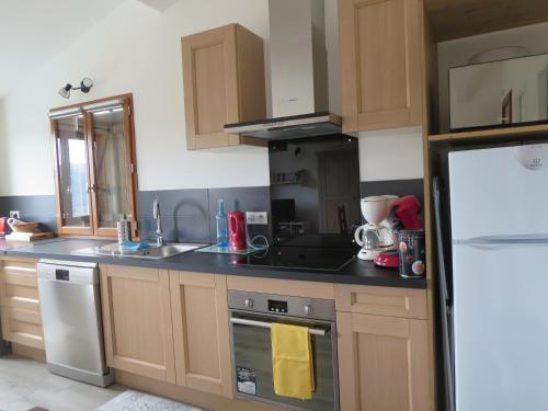 une cuisine avec des armoires en bois et un four à plaques de cuisson dans l'établissement 2P entre mer et montagne, à Gattières