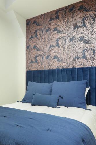 une chambre avec un grand lit avec des oreillers bleus dans l'établissement Apartment Parc des Expositions by Studio prestige, à Paris