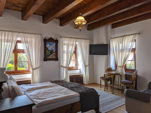 1 dormitorio con 1 cama en una habitación con ventanas en La Teo Pensiune si Pivnita, en Sighişoara
