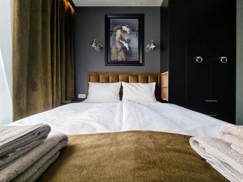 a bedroom with a large bed with white sheets at Silesia Aparthotel in Szczecin