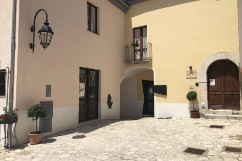 a building with a door and a courtyard with potted plants at B&B Genti delle Alture in Apice
