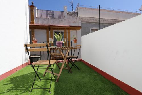 balkon z zieloną trawą, stołem i krzesłami w obiekcie Sweet Sevilla Hostel w Sewilli