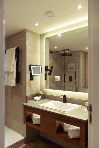 a bathroom with a sink and a large mirror at The Lowry Hotel Manchester in Manchester