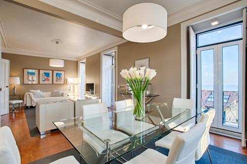 a living room with a glass table and white chairs at Saboia House 515 by Saboia Collection in Cascais