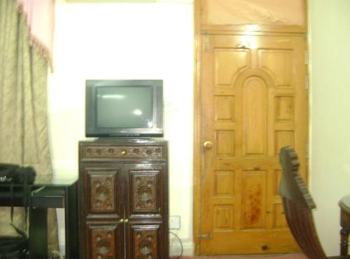 a television sitting on top of a wooden stand next to a door at Hotel Orash Lodge in Nāluchhi