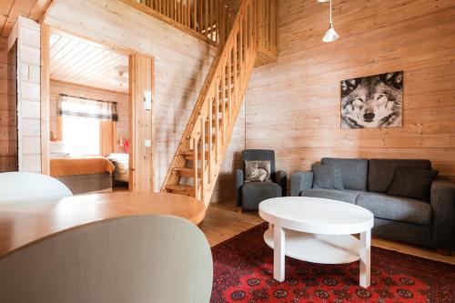 a living room with a couch and a table at Lapland Hotels Ounasvaara Chalets in Rovaniemi