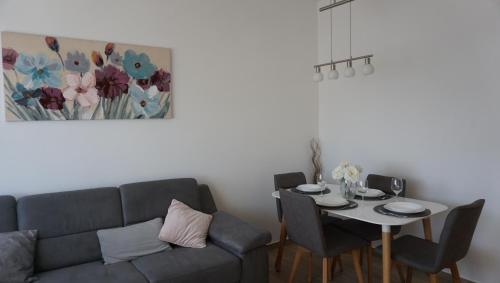 - un salon avec un canapé et une table avec des chaises dans l'établissement Apartman Luka, à Pula