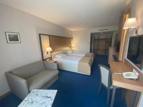 une chambre d'hôtel avec un lit et un canapé dans l'établissement Legends Hotel, à Sofia