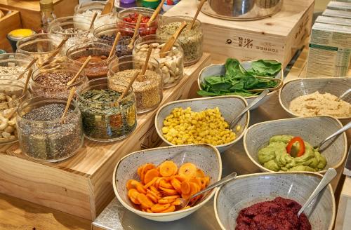 マドリードにあるプチ パレス サンタ バルバラのさまざまな種類の食べ物が入ったボウルが置かれたテーブル