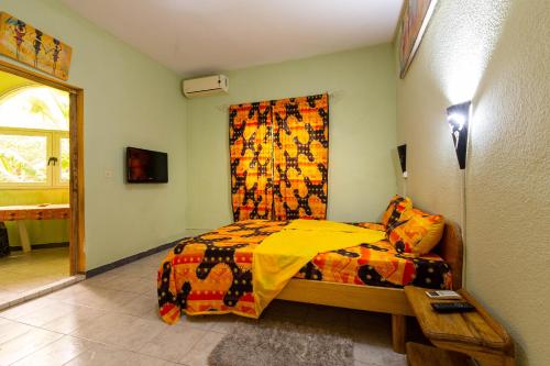 a bedroom with a bed with a colorful blanket at Auberge Africa Thiossane in Saly Portudal