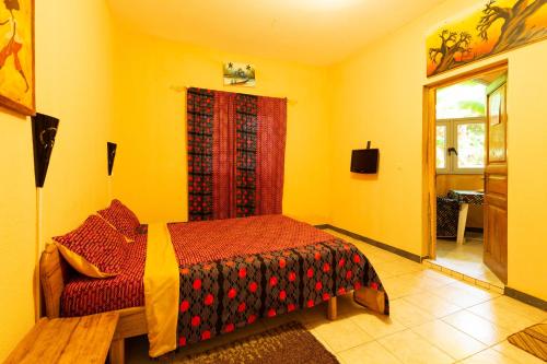 a bedroom with a bed and a red window at Auberge Africa Thiossane in Saly Portudal
