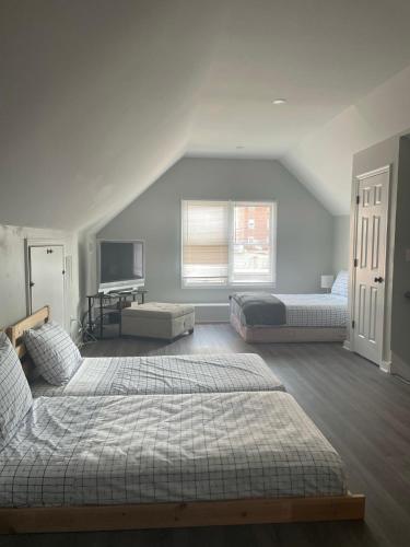 1 dormitorio con 2 camas y TV. en Room near the Beach and Pier Village en Long Branch