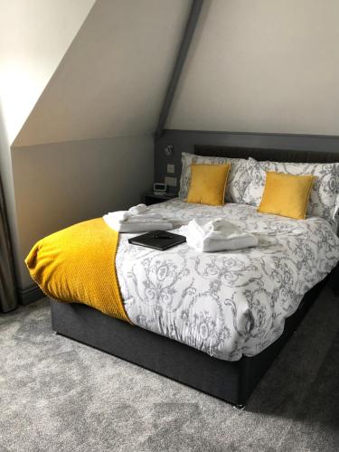 a bedroom with a large bed with yellow pillows at Swanage Haven Boutique Guest House in Swanage