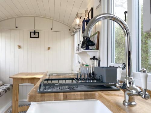uma cozinha com um lavatório e uma bancada em The Duck House em Swansea