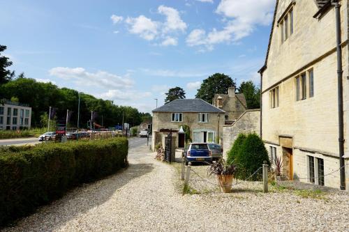 a house with a car parked next to a building at The Coach House and The Stable in Woodchester