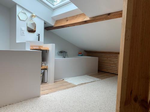 Cette chambre mansardée est dotée d'un plafond voûté et d'une lucarne. dans l'établissement Appartement avec jardin entre lac et océan Hossegor, à Soorts-Hossegor