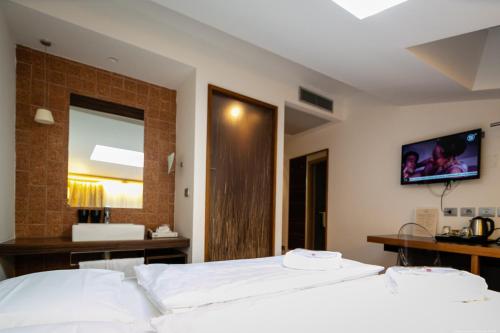 a bedroom with two beds and a television on the wall at Boutique Exclusive B&B in Trento