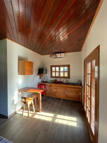 a kitchen with a table and a wooden ceiling at Vila Ypáwa 150 m centro 30 m praia lago verde in Alter do Chao