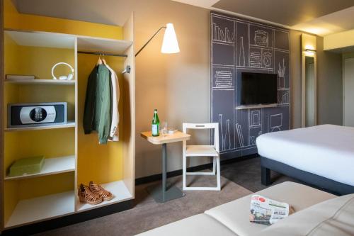 a hotel room with a bed and a desk and a bed and a room at ibis Pontorson Baie Du Mont Saint Michel in Saint-Georges-de-Gréhaigne