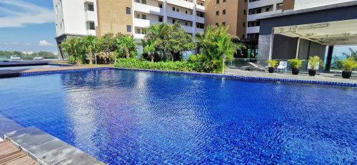 a large blue swimming pool in front of a building at Dwharf Seaview Executive Suit PortDickson in Port Dickson