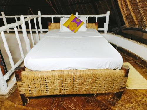 a wicker bed with a pillow on top of it at Upani in Diani in Diani Beach